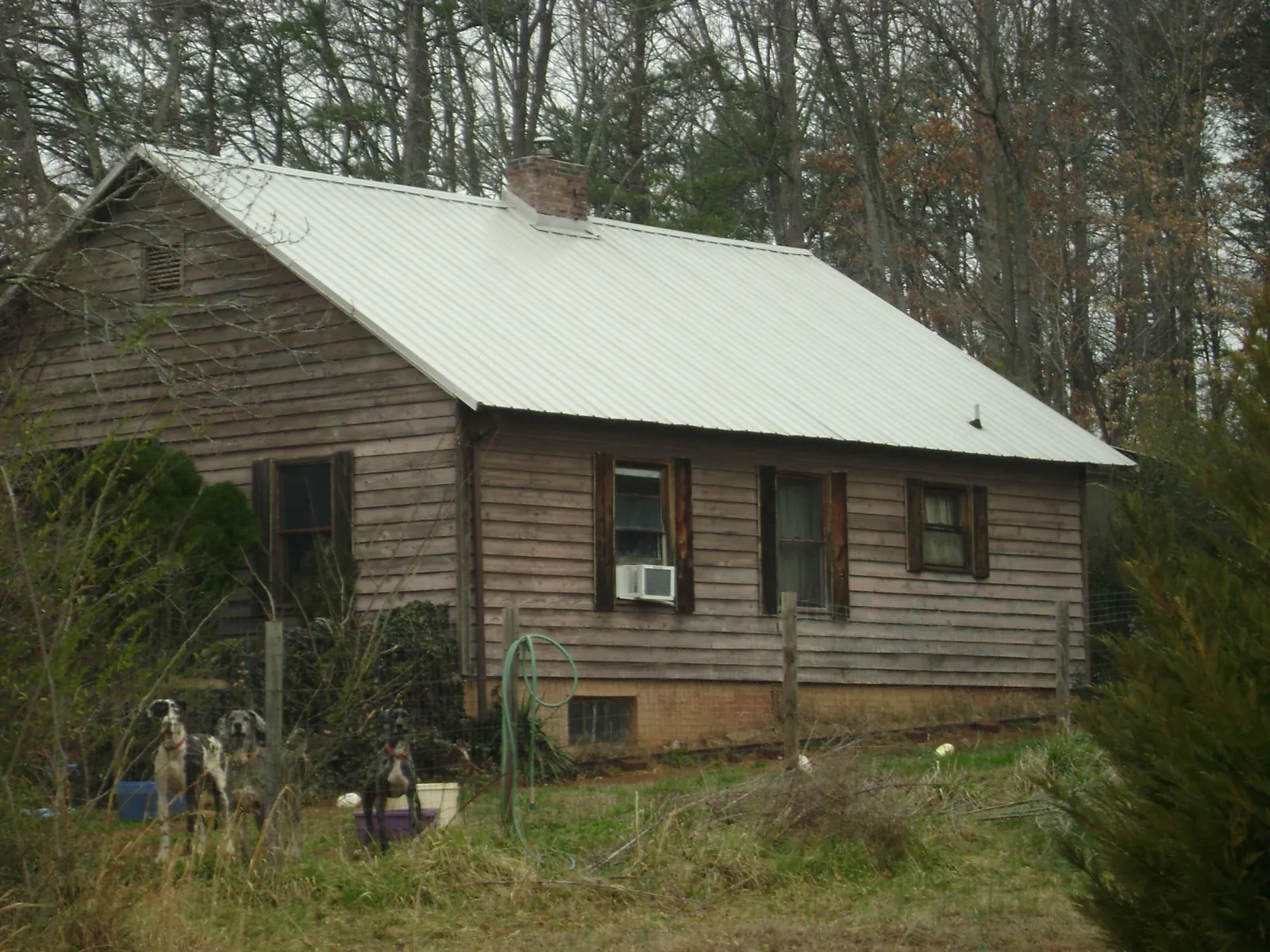 White metal roof on an old wood sided farmhouse, from a Asphalt Shingle Roof Repair job in Ada